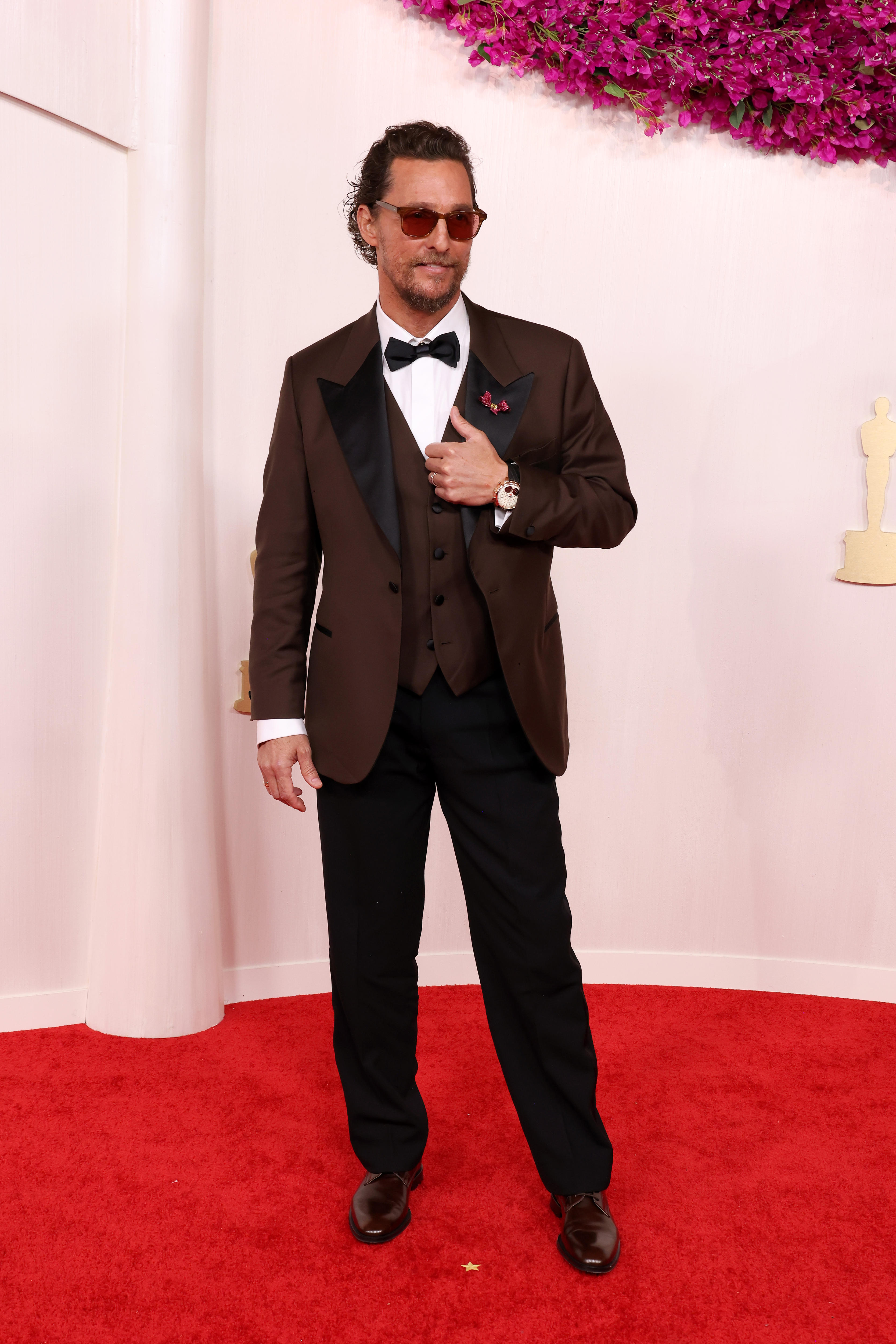 Matthew McConaughey con traje burdeos en la alfombra roja de los Oscar