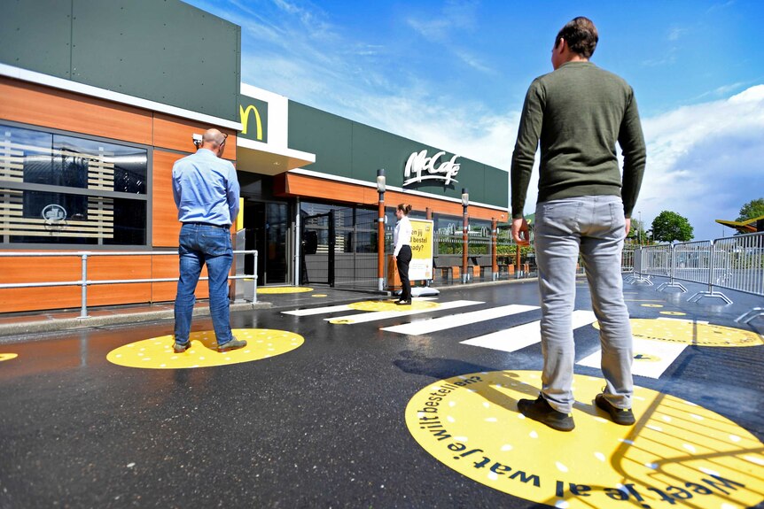 Customers wait outside on social distancing markings at a prototype McDonald's in the Netherlands.
