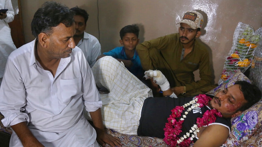 Relatives visit with Mohammad Zubair, a passenger who survived a plane crash, at his home in Karachi, Pakistan.