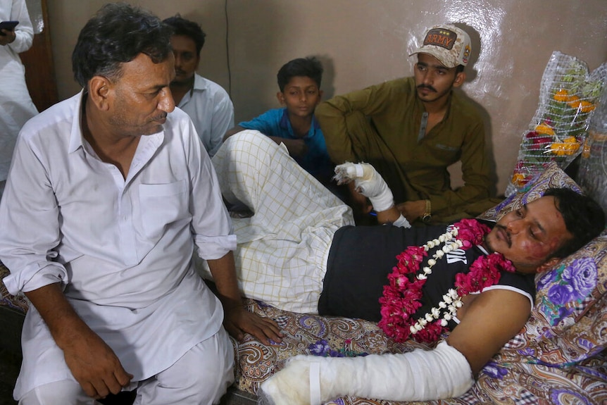 Relatives visit with Mohammad Zubair, a passenger who survived a plane crash, at his home in Karachi, Pakistan.