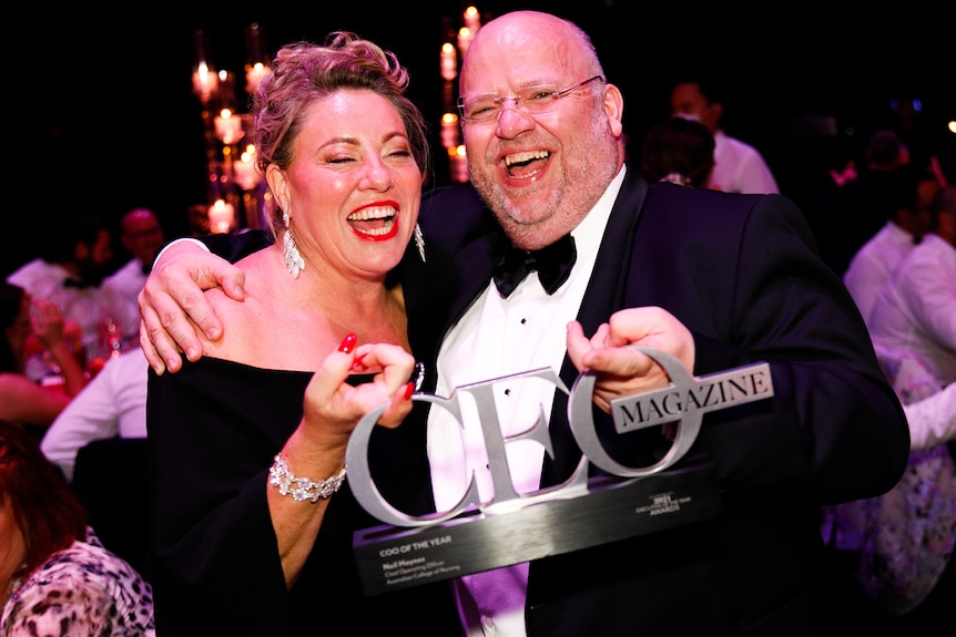 Kylie Ward and Neil Haynes laughing and holding up a CEO magazine 