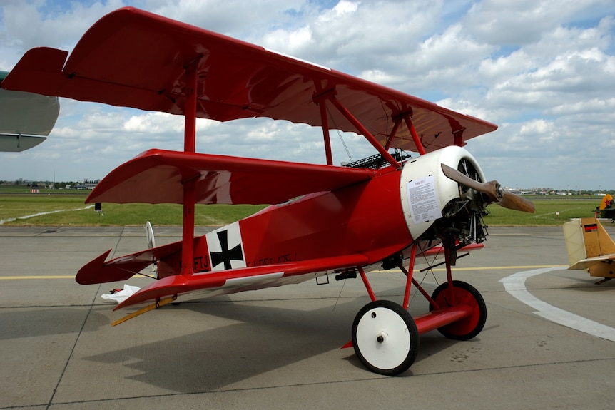 A triplane painted red and white on a air field