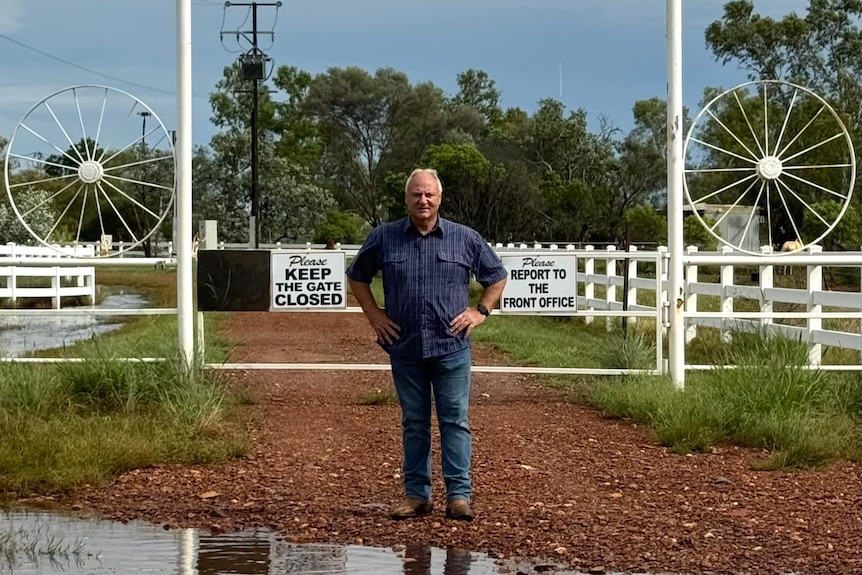 Steve Edgington stands in front of the white closed double gate of the Juno Center with his hands on his hips.