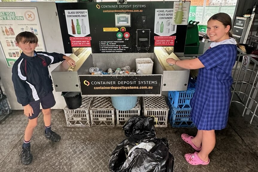 boy and girl cashing in their cans at a depot