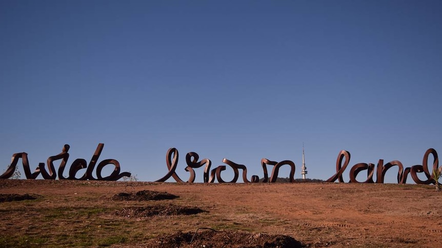 A sculpture at the National Arboretum in Canberra spelling out 'wide brown land'.