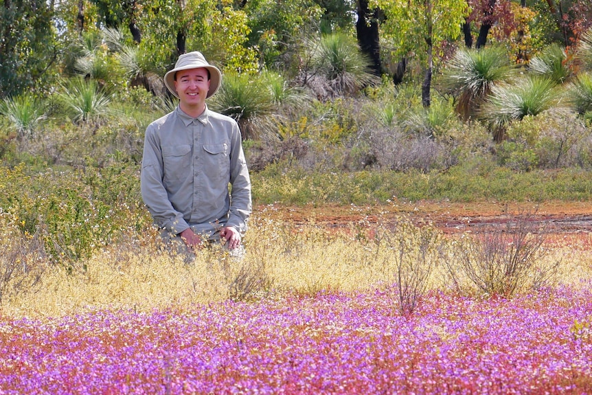 A man in a field of colourful flowers.