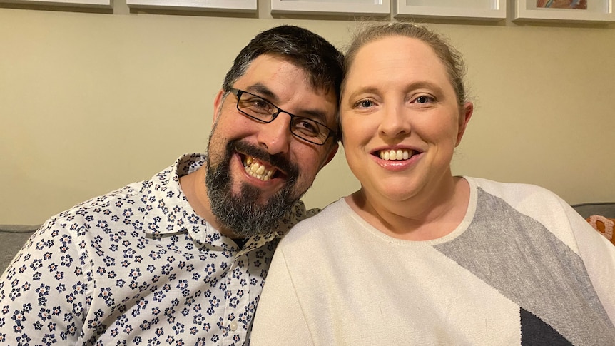 Man and woman smiling in their home, in a story about what to do when you're priced out of buying property.