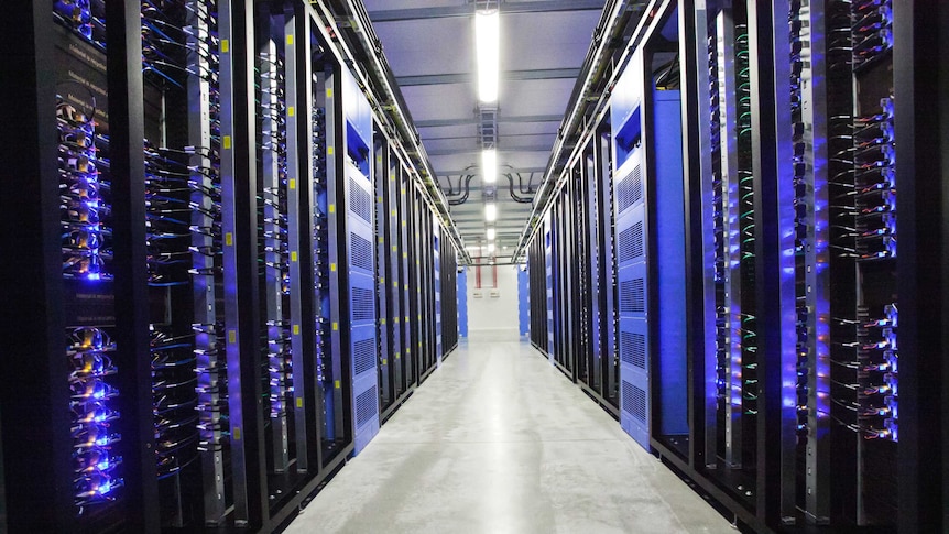 Racks of computer servers on either side of a hallway