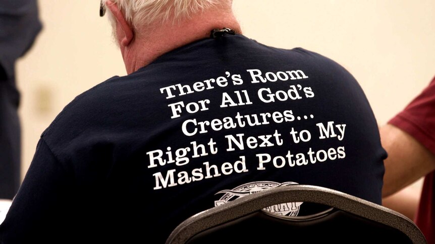 A man wears a slogan shirt at a meat festival in the United States.