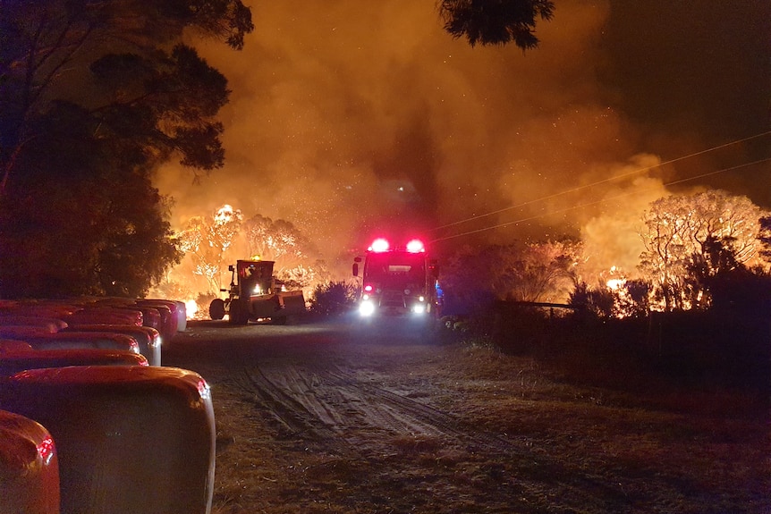 fire trucks attend a bushfire at night