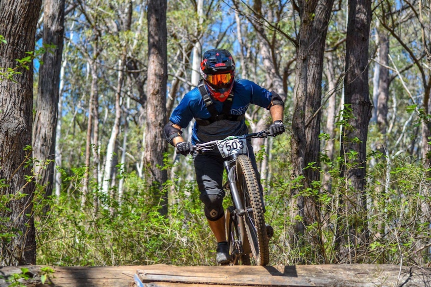 A mountain bike rider rides along a bush track