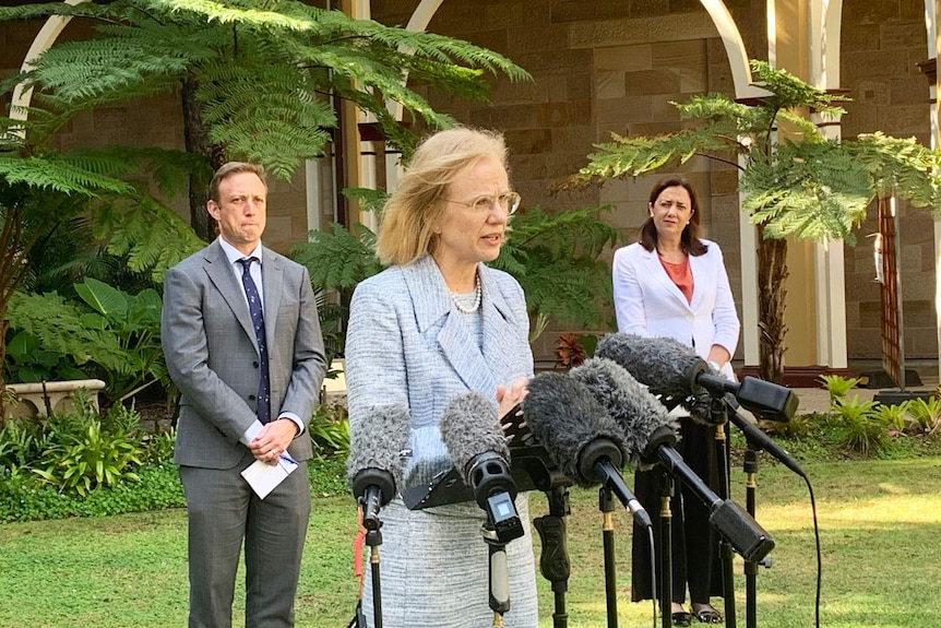 Dr Jeannette Young speaks at a press conference, with Steven Miles and Annastacia Palaszczuk nearby.