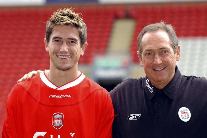 A young Harry Kewell stands smiling next to Liverpool manager Gerard Houllier.