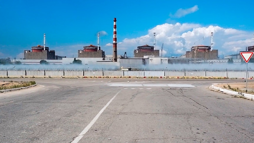 The reactors of Zaporizhzhia Nuclear Power Station are seen from behind a concrete fence.