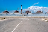 The reactors of Zaporizhzhia Nuclear Power Station are seen from behind a concrete fence.