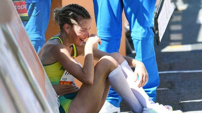 Claire Tallent of Australia cries while sitting on the ground after being disqualified