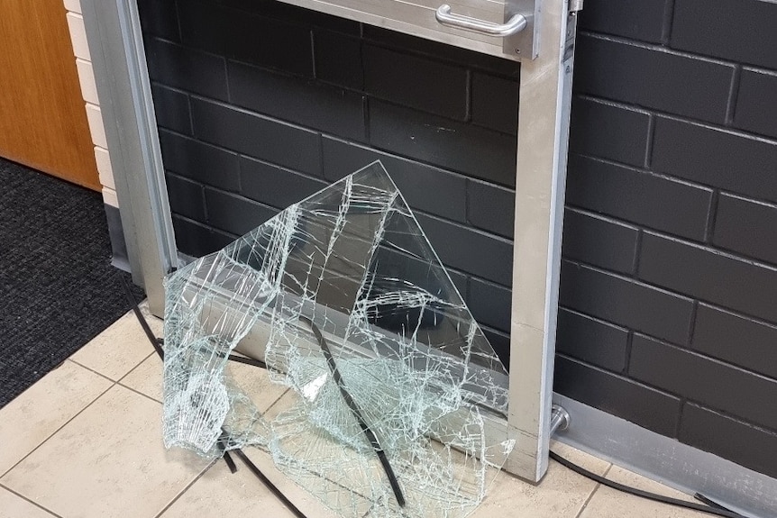 A glass door with a smashed bottom panel.