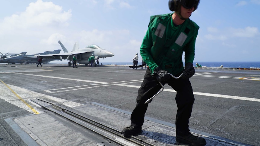 A crew member on board the flight deck of the US aircraft carrier Carl Vinson in the South China Sea. (Photo: Adam Harvey)