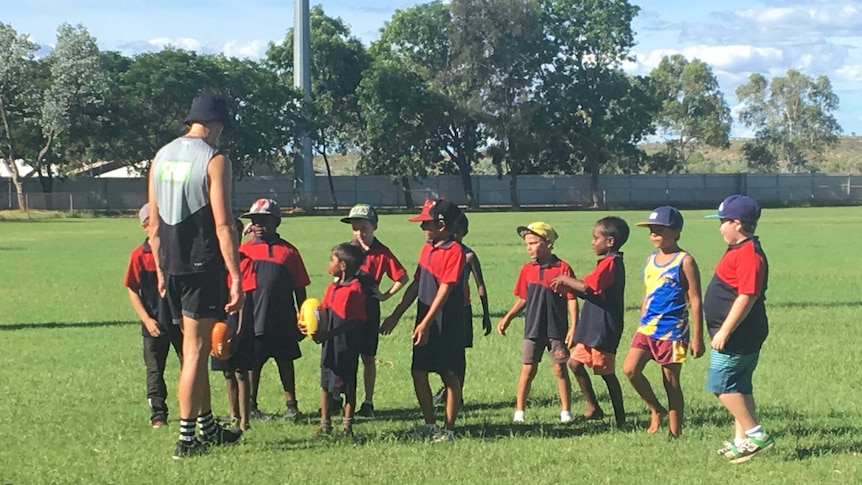 Collingwood players take kids for a training session