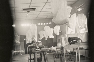 An historic photo of an empty, rudimentary hospital ward