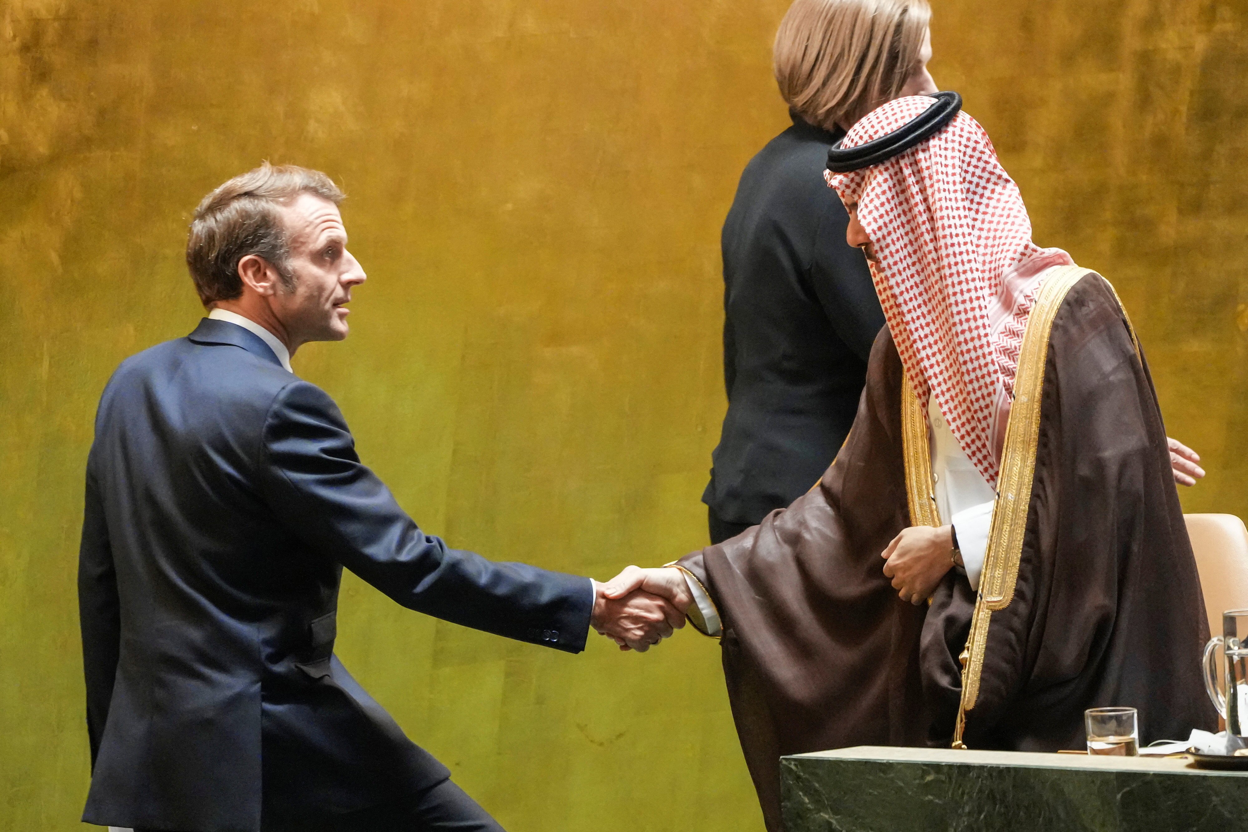Emmanuel Macron shakes hands with Faisal bin Farhan Al-Saud.