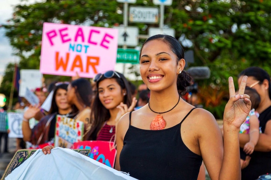 Guam woman shows the peace symbol at a public rally in response to the North Korean crisis.