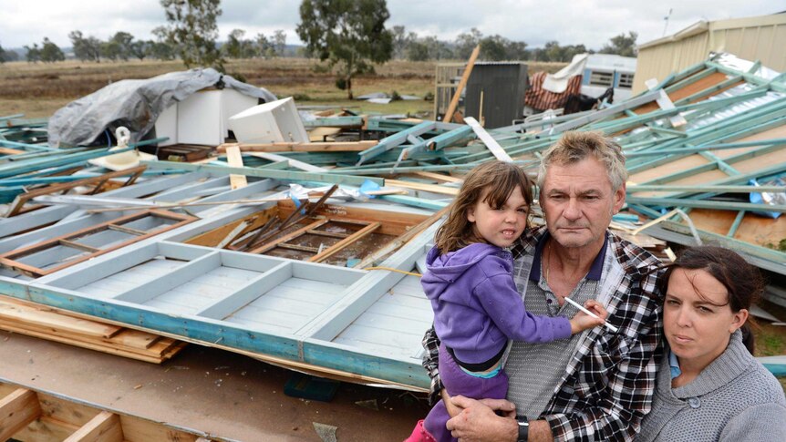 The Short family stand next to their destroyed house.