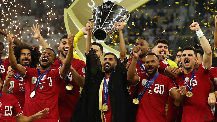 Qatar players hold the trophy after winning the men's Asian Cup final.