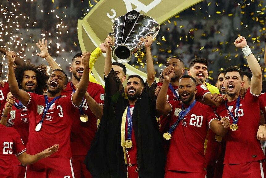 Qatar players hold the trophy after winning the men's Asian Cup final.