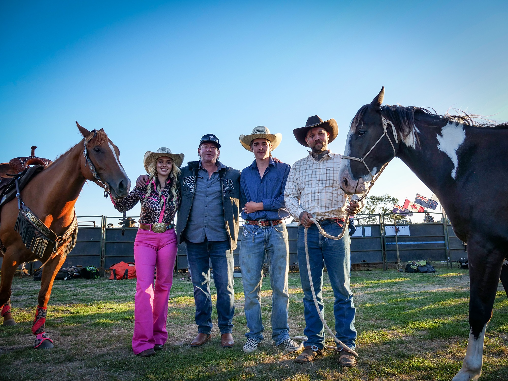 A family photo of four people and two horses