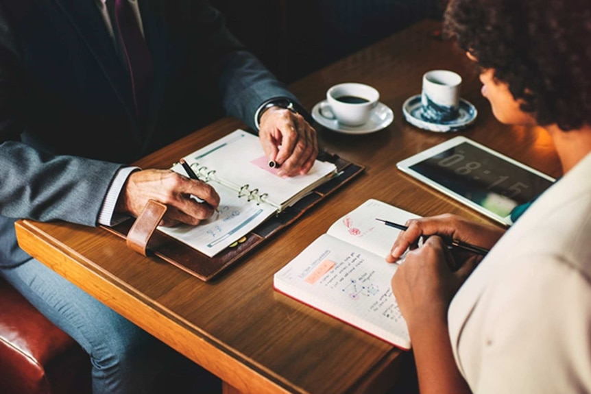 A man and a woman in a business meeting to depict what to do when you face pregnancy discrimination.