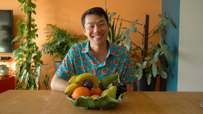 Melbourne fruiterer Thanh Truong smiles while sitting in front of a fruit bowl.