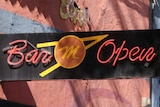 A black 'Bar Open' sign outside the Mustang Bar in Perth.