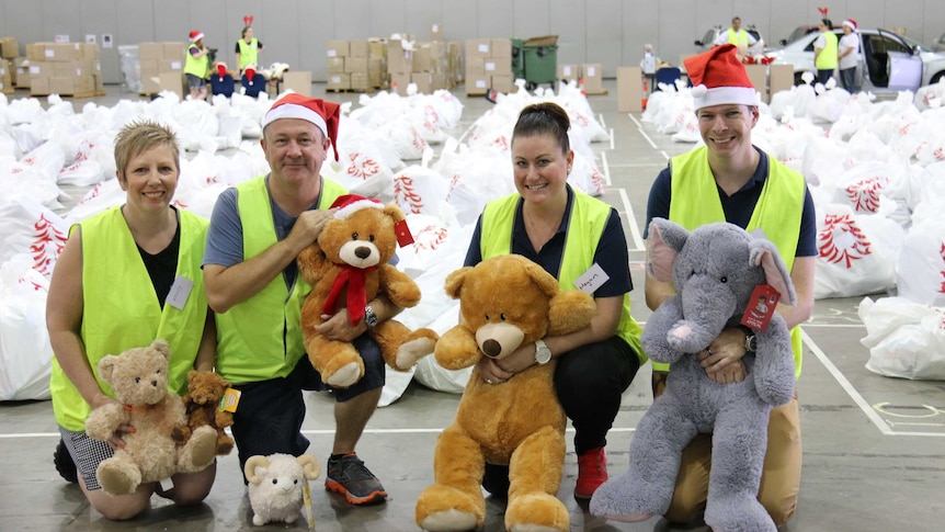 Volunteers and The Smith Family staff in front of hundreds of gifts which had been collected after six months of planning.