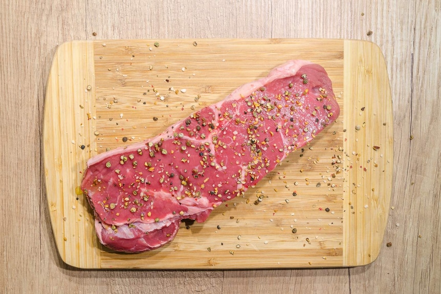 Raw meat on a wooden chopping board.