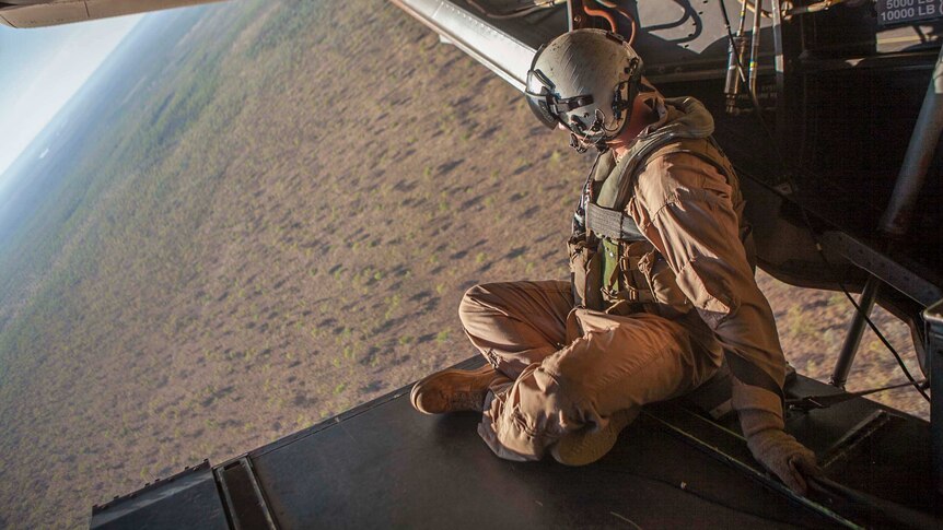 Sergeant Aaron Longberry sits on the ramp of an MV-22 Osprey helicopter