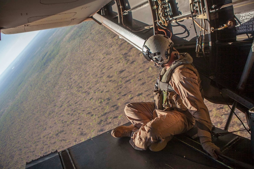 Sergeant Aaron Longberry sits on the ramp of an MV-22 Osprey