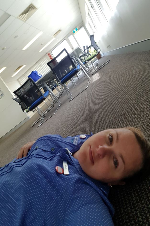 Woman lays on floor in staff room