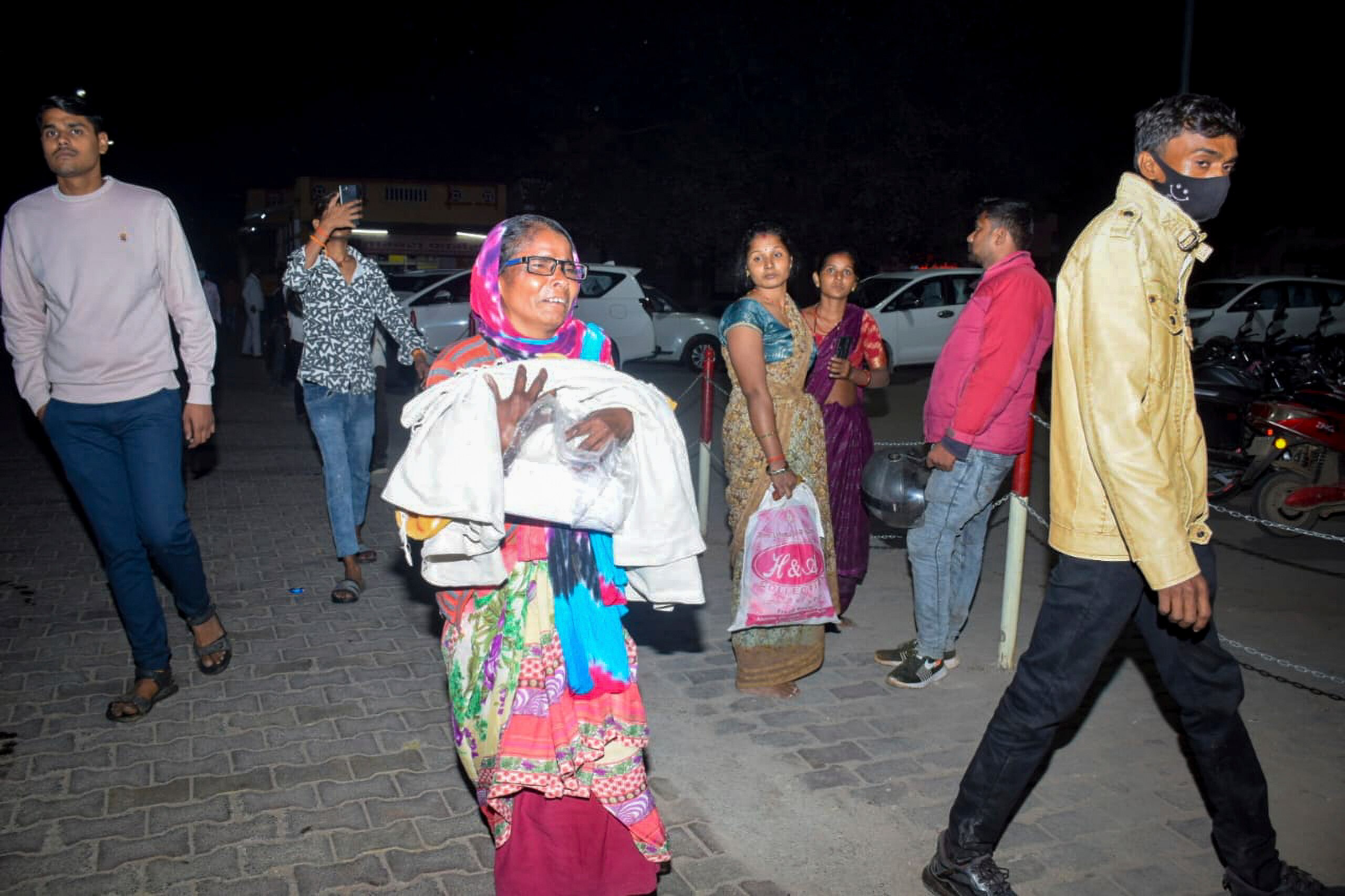 A woman holds a child in her arms after a fire in India