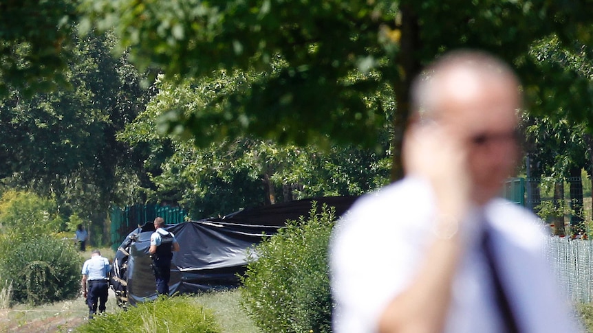 French police stand guard next to a black plastic sheet outside the Air Products company.