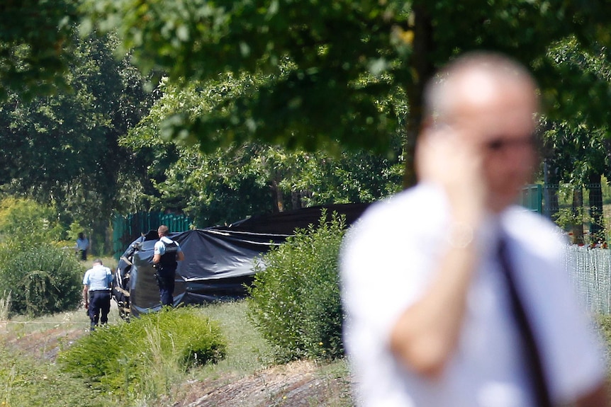 French police stand guard next to a black plastic sheet outside the Air Products company.