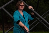 A woman poses amongst a series of metal bars.