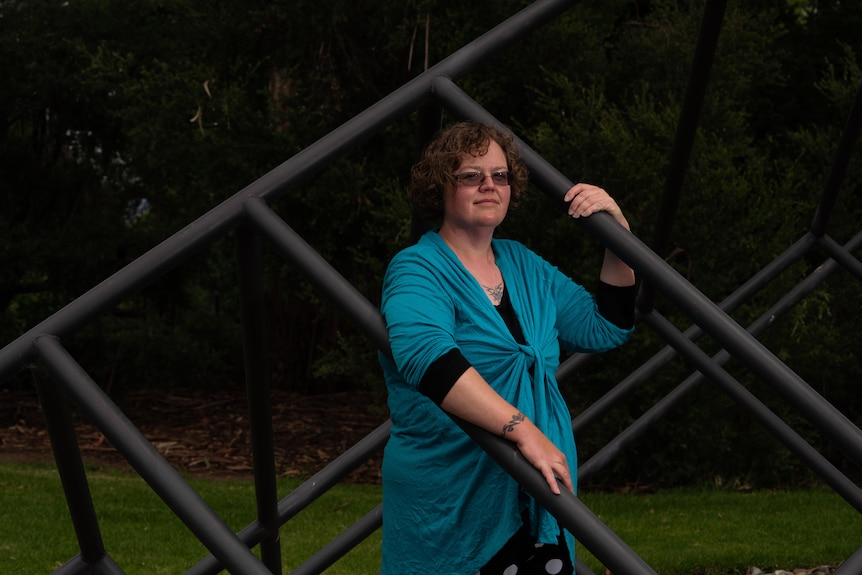 A woman standing between a series of metal bars.