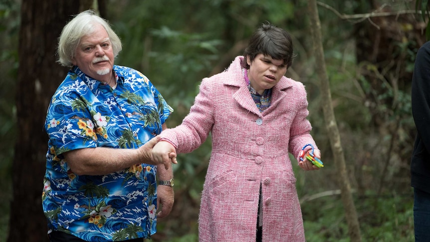 Russell wears a blue Hawaiian shirt and walks his daughter through a national park.