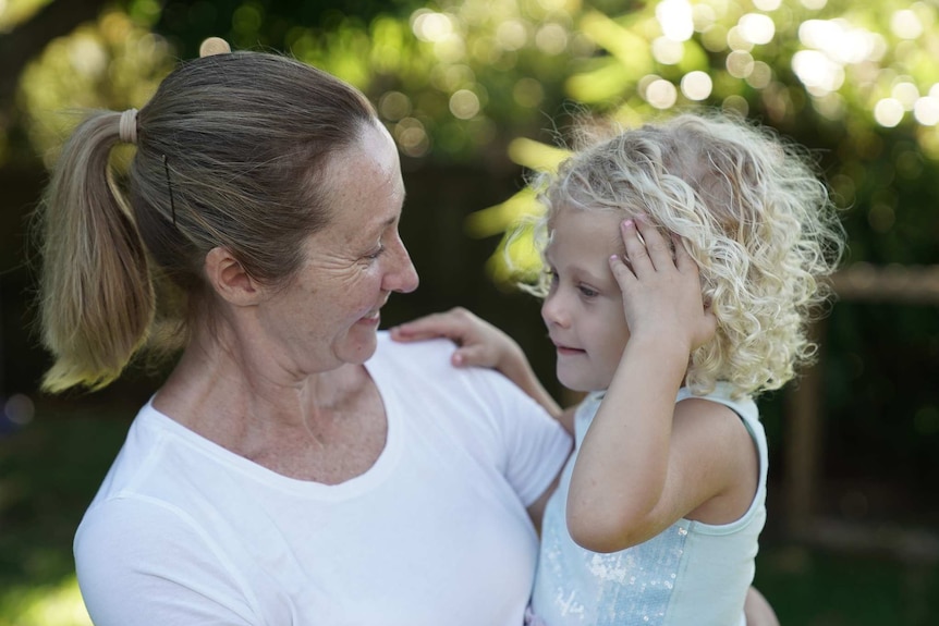 Mother and daughter face each other.