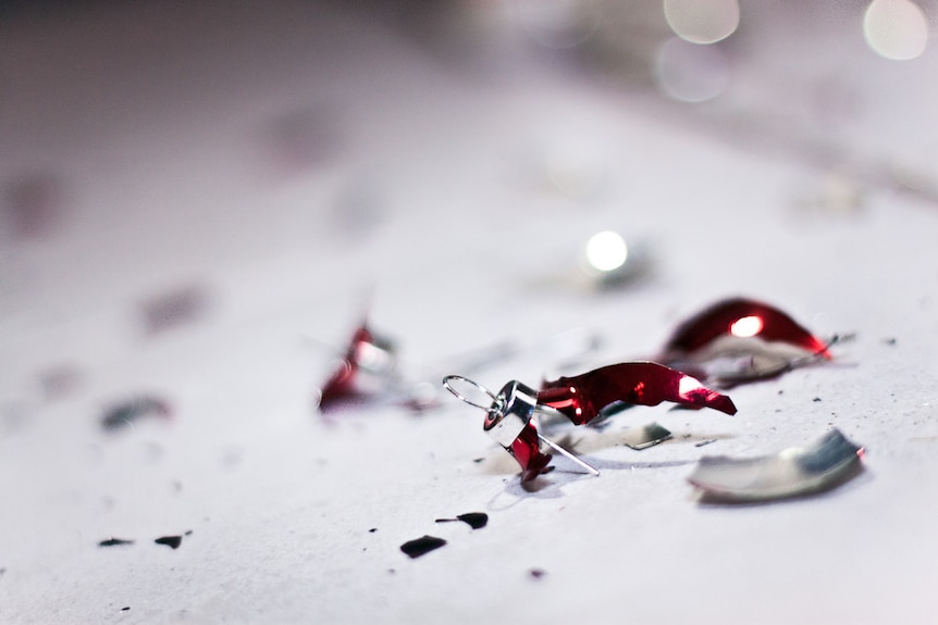 Close up of a broken red and silver Christmas bauble.