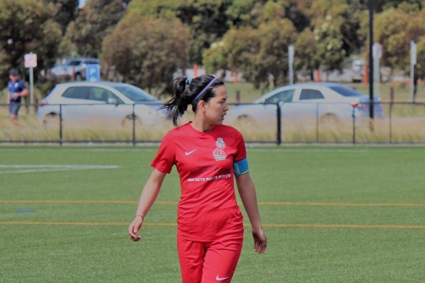 A women standing on the field while playing soccer 