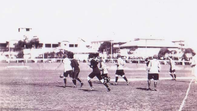 A historic black and white image of the women playing football at the first public match of women's football in Queensland