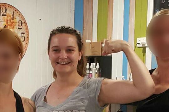 Sophie flexes her arm muscle in a picture with her fellow bootcamp attendees.