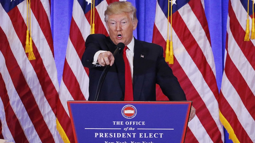 Donald Trump points and appears to argue with a CNN reporter at a press conference